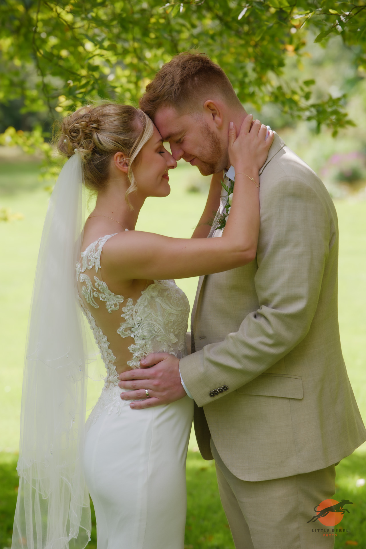 Bride and groom embracing in the grounds of Askham Hall