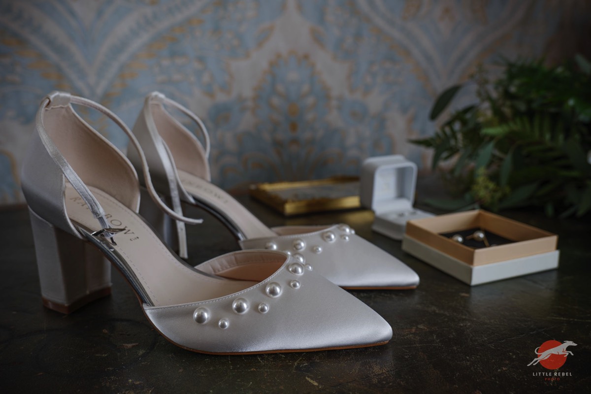 Pearl-detailed bridal shoes displayed with wedding jewellery at Askham Hall