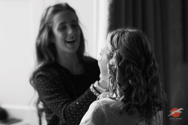 Black-and-white photograph of a bride having her make-up applied at Askham Hall