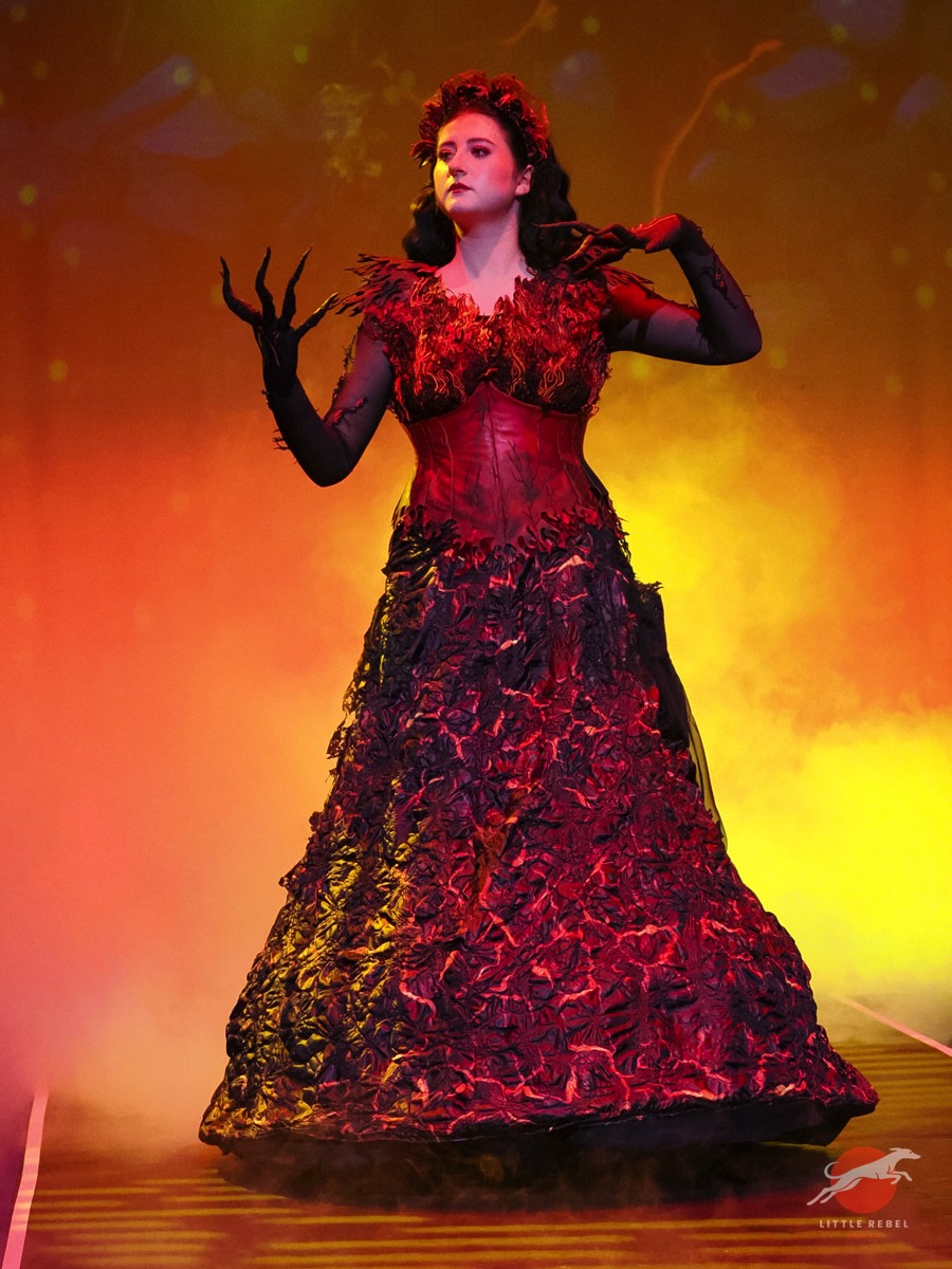 Model wearing Zara Williams’ Pele, Hawaiian goddess of fire and volcanoes, costume against a fiery stage backdrop at University of Huddersfield