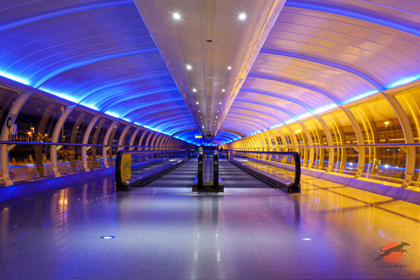 Blue-lit Skylink walkway and travelators at Manchester Airport