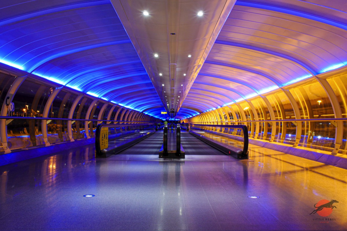 Blue-lit Skylink walkway and travelators at Manchester Airport