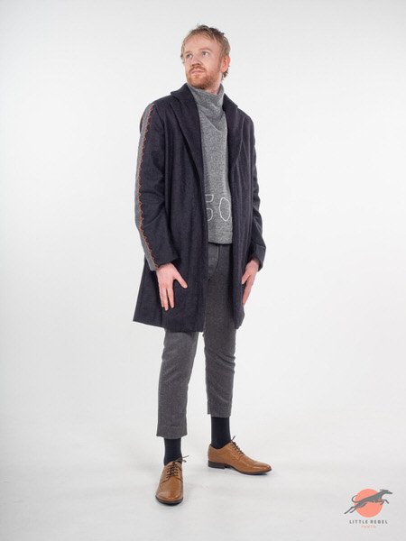 Male model wearing a charcoal coat with orange stitching during a University of Huddersfield fashion shoot