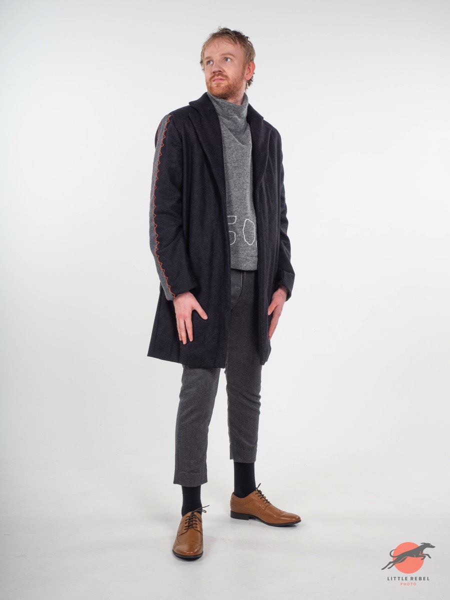 Male model wearing a charcoal coat with orange stitching during a University of Huddersfield fashion shoot