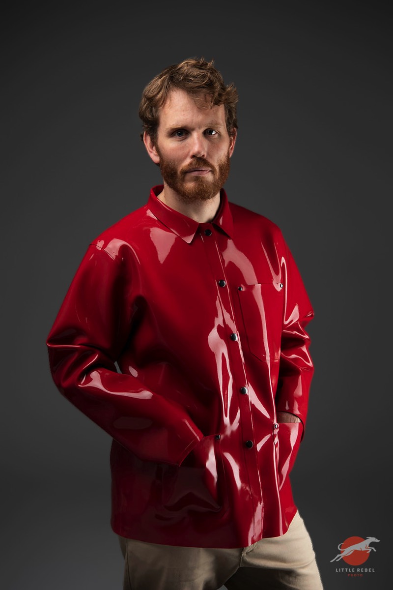 Male model wearing a glossy red rubber chore jacket by Wrapped in Rubber